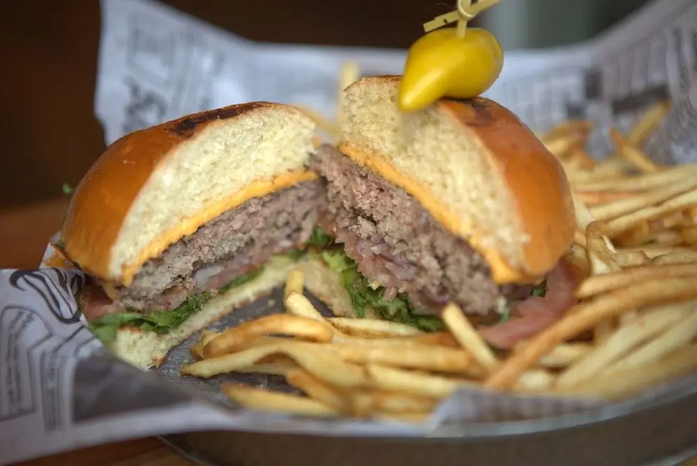 there is a hamburger and fries in a basket on a table