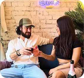 they are sitting on a couch with a glass of wine