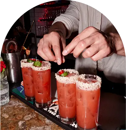 someone is putting a garnish on a bloody drink