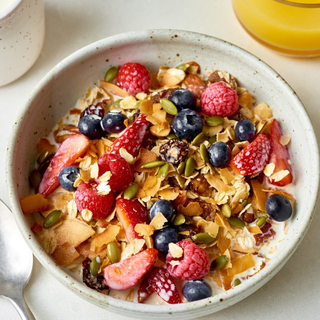there is a bowl of cereal with fruit and nuts in it