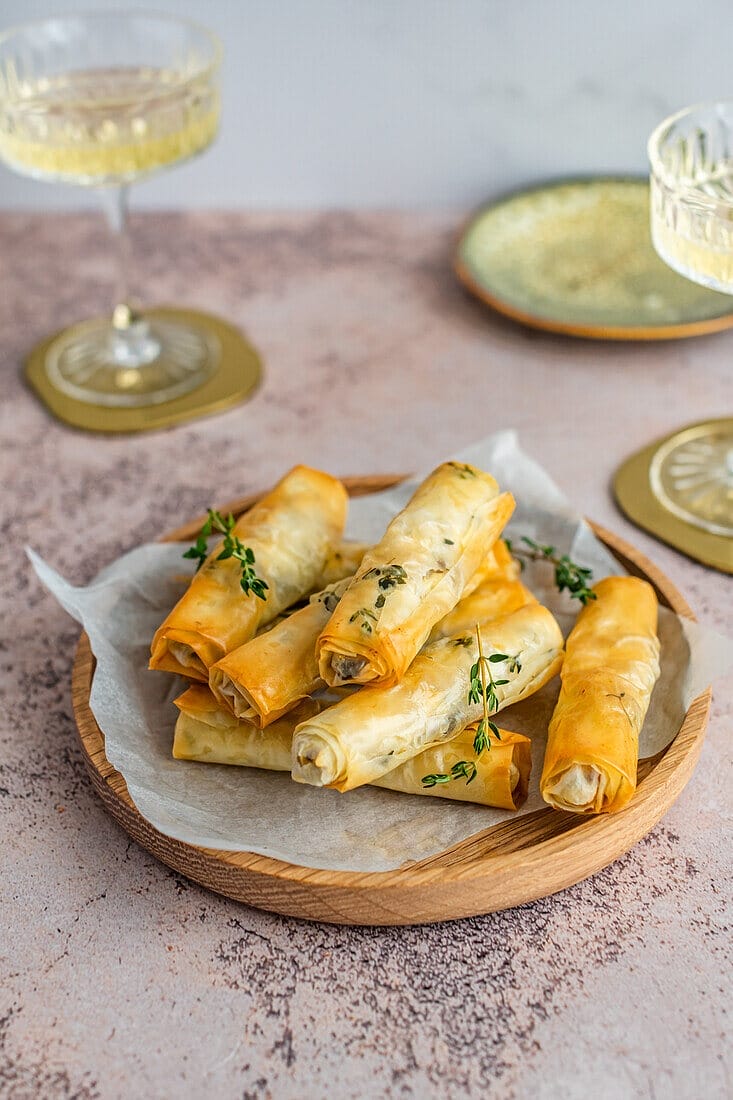 there are some food on a plate with a glass of wine