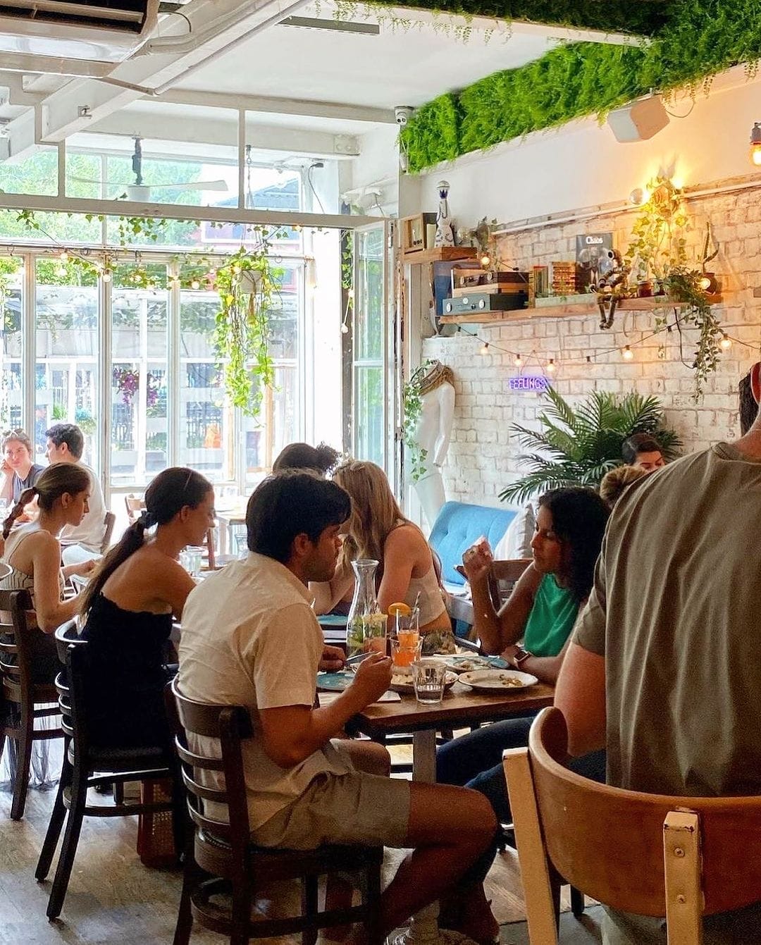 people sitting at tables in a restaurant eating food and drinking