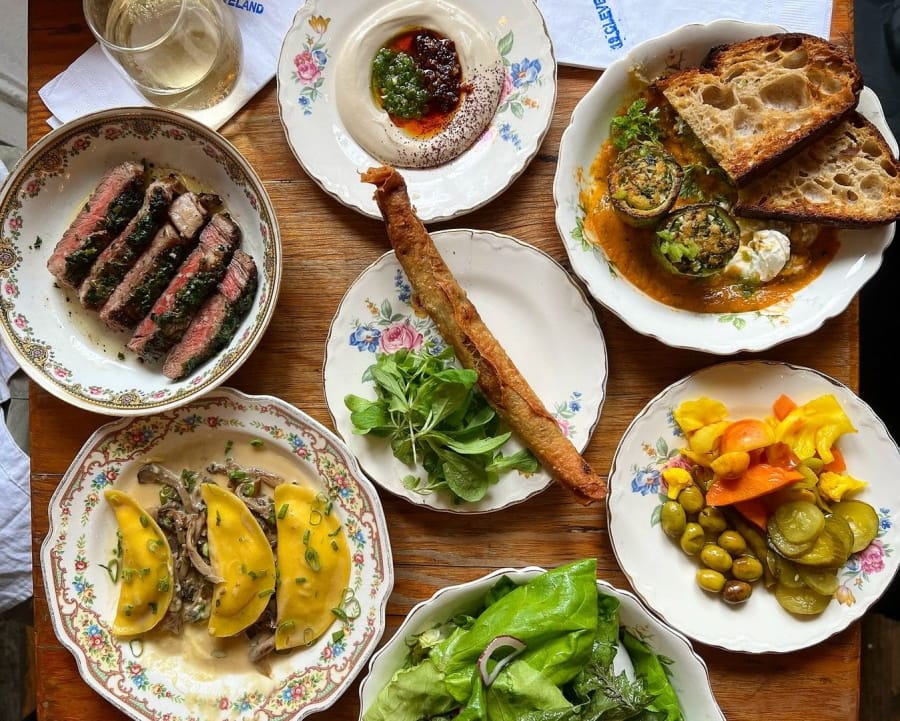 a close up of a table with plates of food and a glass of wine