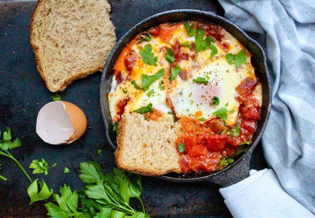 there is a pan with eggs and bread on a table