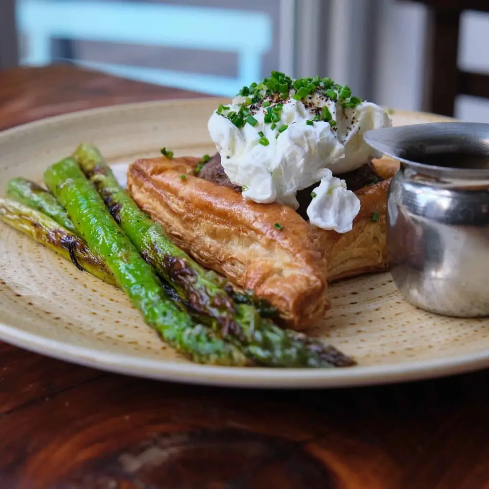 there is a plate of food with asparagus and whipped cream