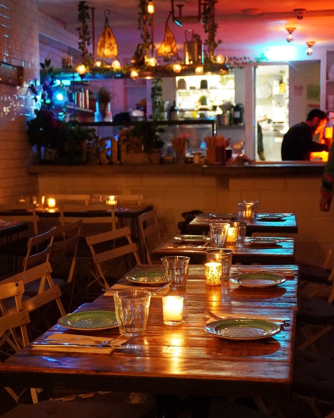 there are many plates and glasses on the table in the restaurant